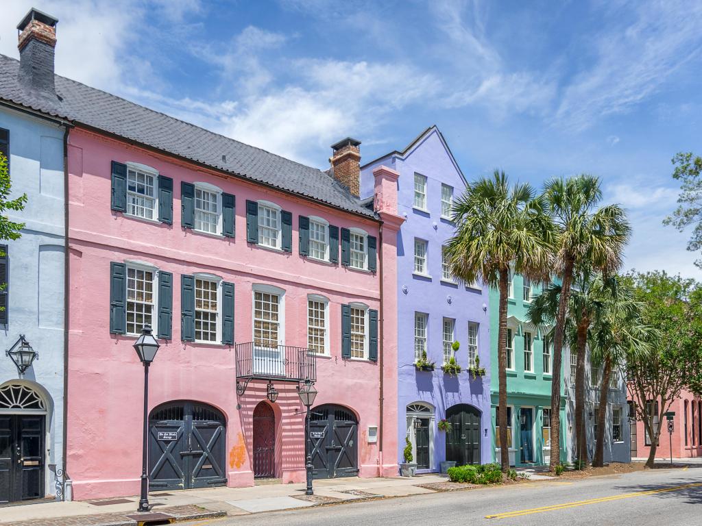 Pastel pink, blue and green fronted houses and palm trees along famous Rainbow Row
