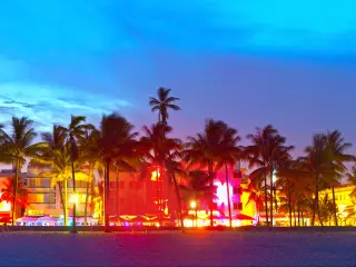 Ocean Drive, Miami Beach, Florida at night with palm trees, hotels and bright lights 