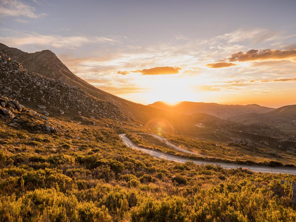 Sunset along the mountain pass with expansive views of rugged landscape 
