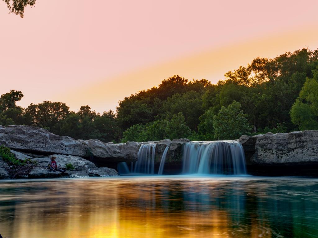 Onion creek running through Mckinney Falls, Texas, USA at sunset with trees in the background.