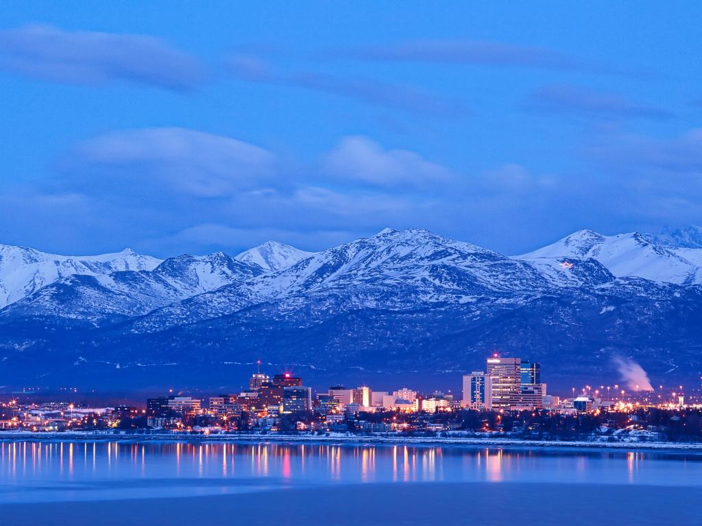 Landscape of Anchorage reflecting on the water, showing mountains in the distance in the evening light