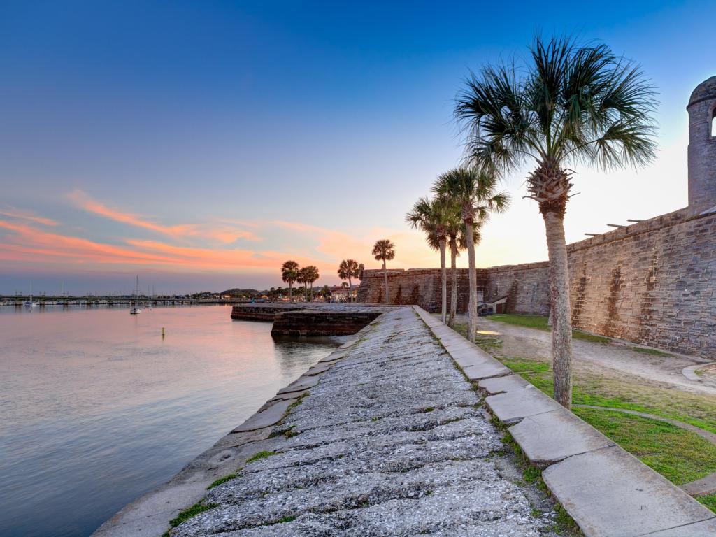 St Augustine, Florida, USA taken at the Spanish fort at sunset with palm trees lining the edge.