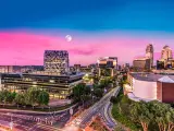 The skyline of Sandton district of the city with a pink sunset, full moon in the background