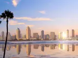 San Diego, California, USA  with the city downtown in the distance and the water reflecting the skyscrapers in the foreground, palm trees and taken at sunset. 