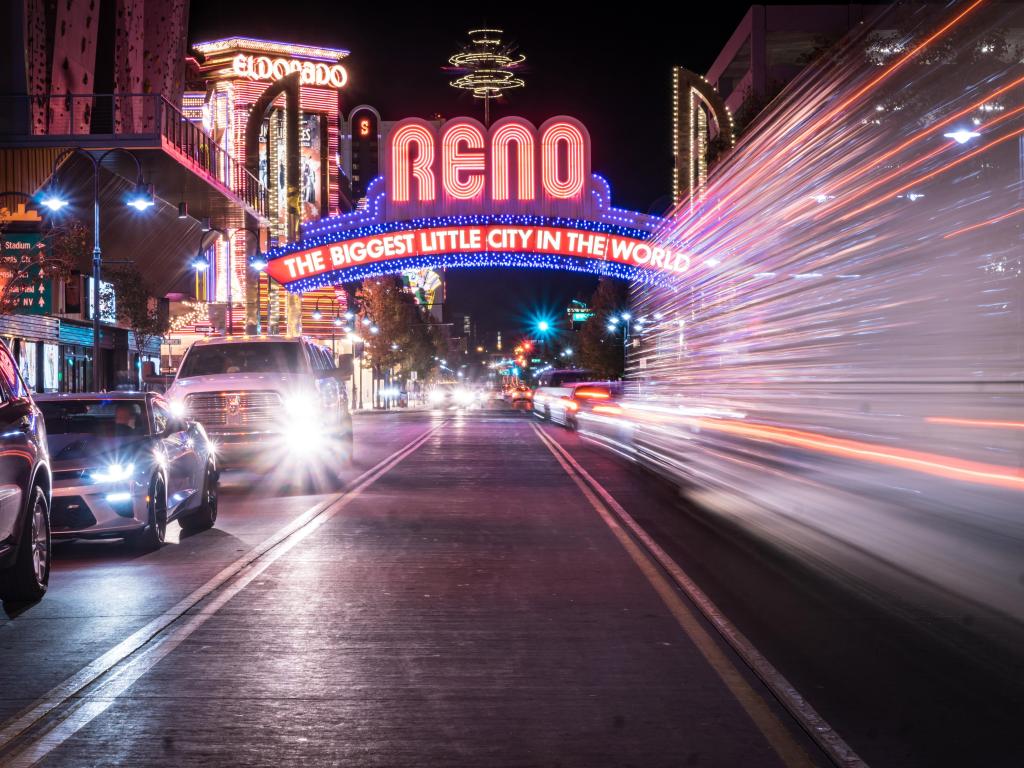 Reno at night with cars speeding through with lights on