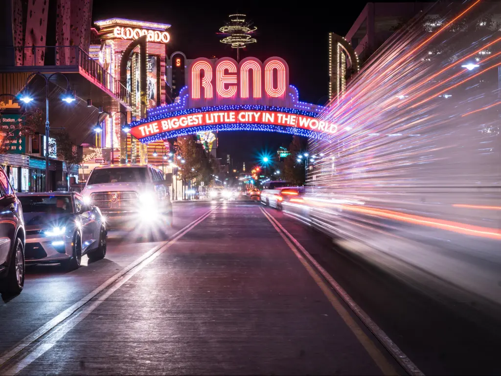 Reno at night with cars speeding through with lights on