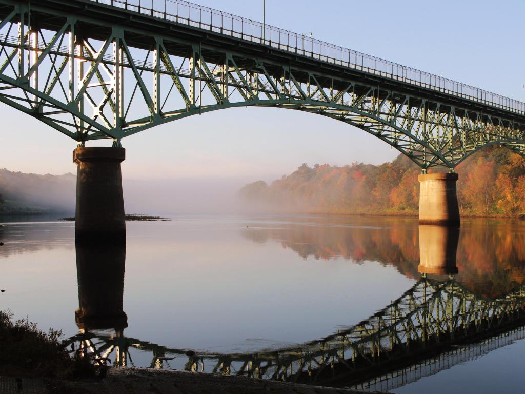 Kennebec River, Rail Trail in Autumn, the photo depicting Kennebec Memorial Bridge, Augusta, Maine, USA on a sunny day.