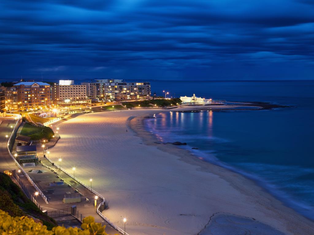 Newcastle, NSW, Australia at twilight with the beach and sea on the other side of the city.