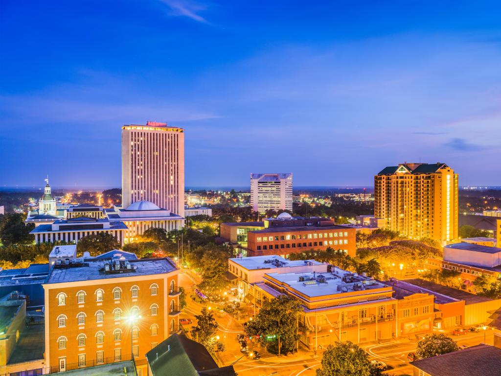 Tallahassee, Florida, USA with the downtown skyline at night with street lights and the city glowing in yellow and the sky dark blue.