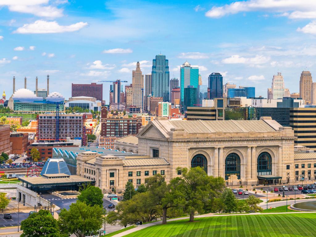 Kansas City, Missouri, USA downtown skyline with Union Station and grass in the foreground taken on a sunny clear day.