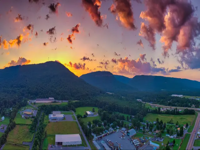 A view of Dayton, Tennessee at sunset with the mountains in the background and buildings dotted around