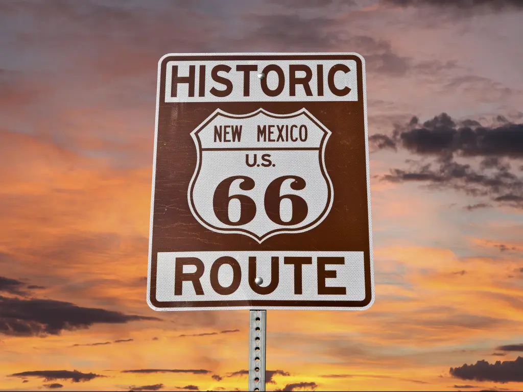 Historic Route 66 New Mexico sign with sunset sky.