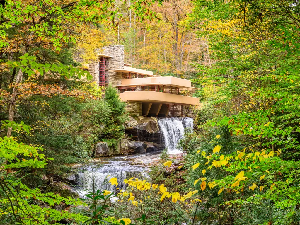 Famous Fallingwater house on a bright day, framed by green tree foliage