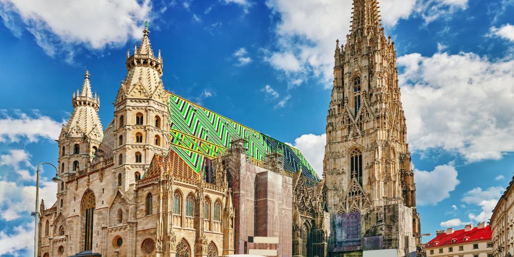 The exterior of St Stephen's Cathedral, Vienna, with a huge spire and green and blue tiled roof