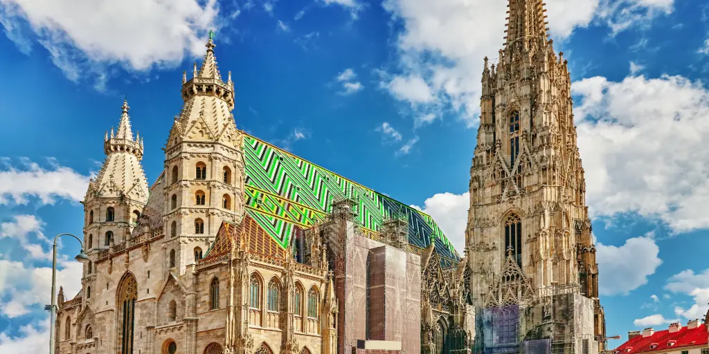 The exterior of St Stephen's Cathedral, Vienna, with a huge spire and green and blue tiled roof
