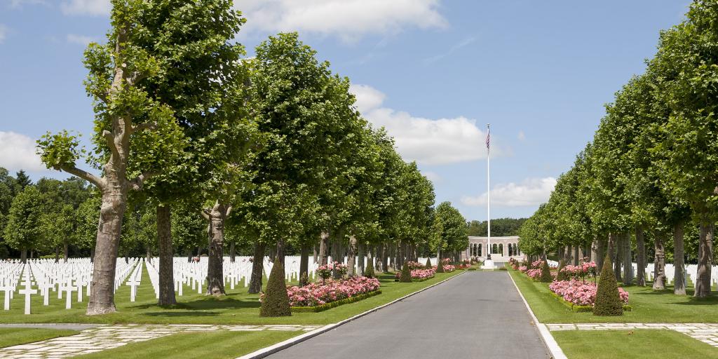 The boulevard of Oise Aisne American Cemetery, France, with rows of crosses either side and the monument visible at the end