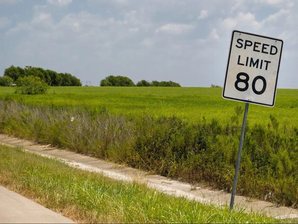 A speed limit sign by the road in Texas showing a maximum of 80 miles per hour