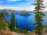 View of Crater Lake, Oregon, with trees in the foreground.