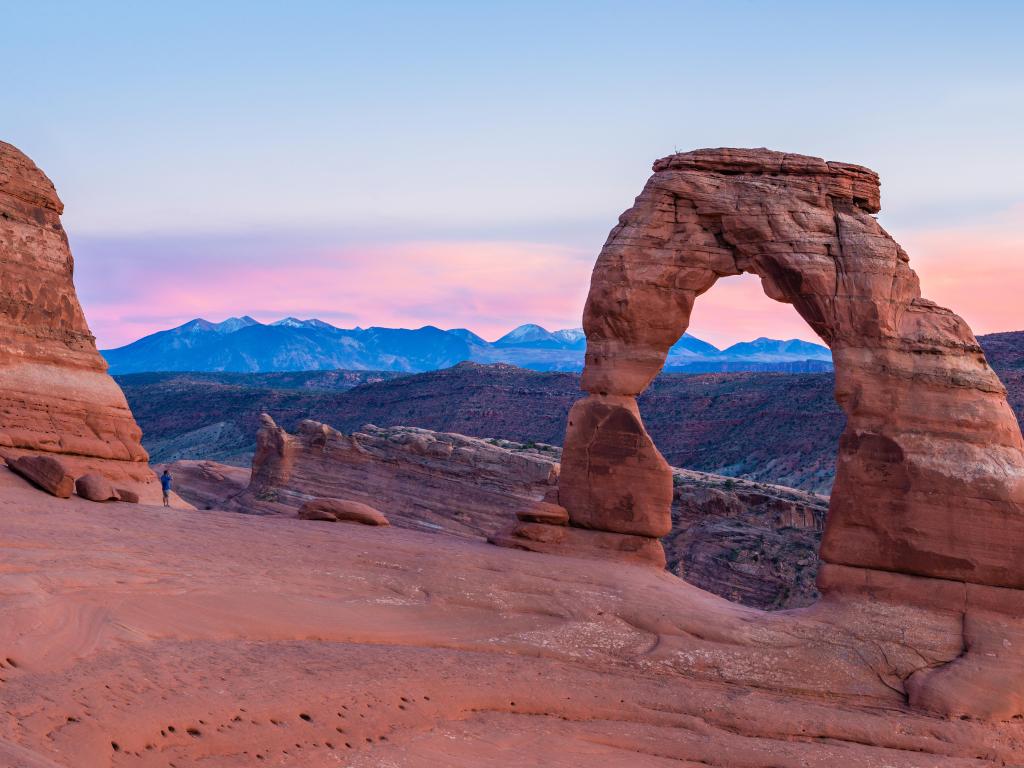 Arches National Park, Utah, USA with the Delicate arch at sunset and mountains in the distance.