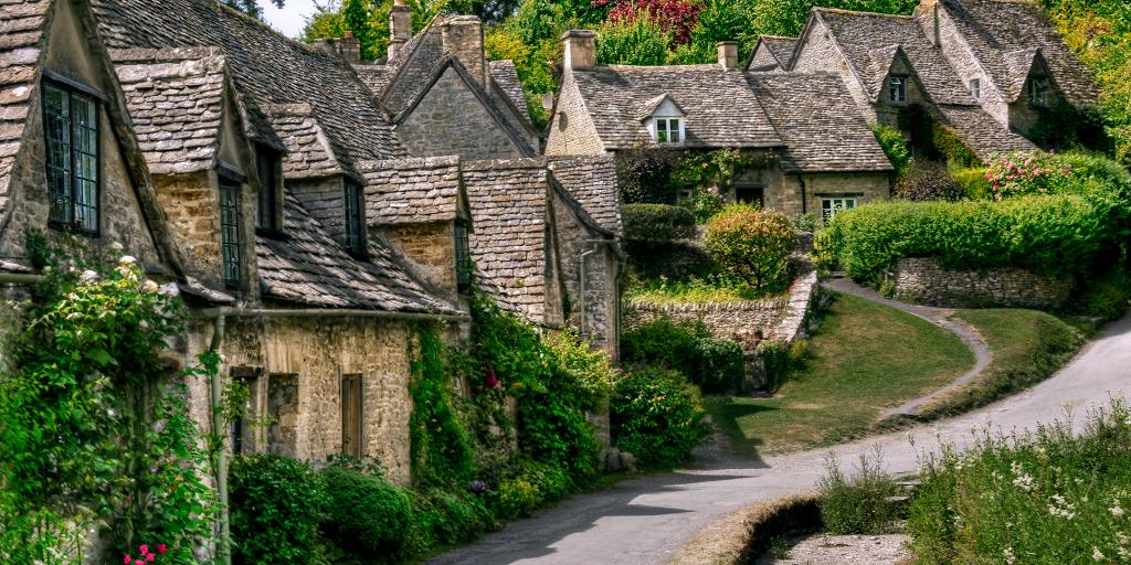 Stone cottages covered in vines line a street in the Cotswolds