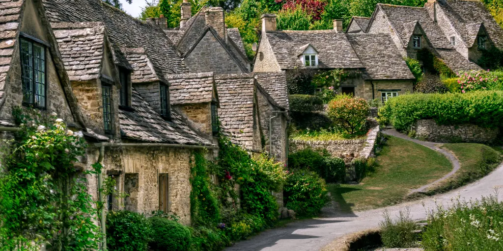 Stone cottages covered in vines line a street in the Cotswolds