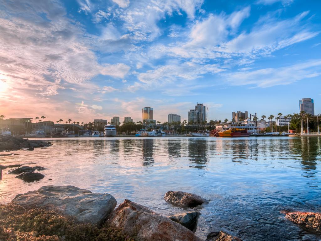 Long Beach, California, USA with a view of the Harbor and rocks in the foreground taken just before sunset.