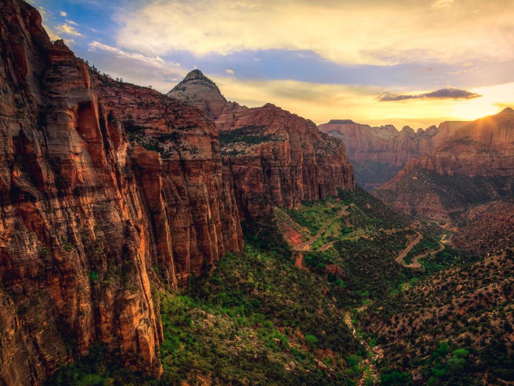 Zion Canyon, Zion National Park, Utah, USA with a sunset in the distance against the red rocky canyons and deep valley below. 