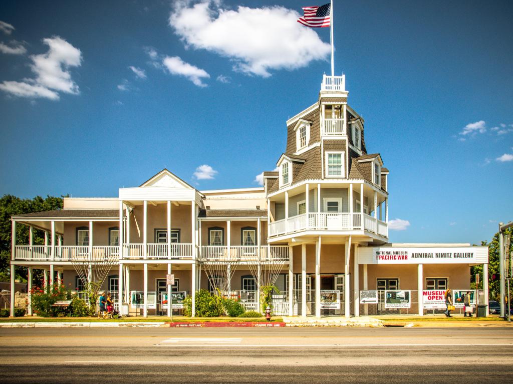 Historic white wood built building with balconies, verandah, turret, flying the stars and stripes
