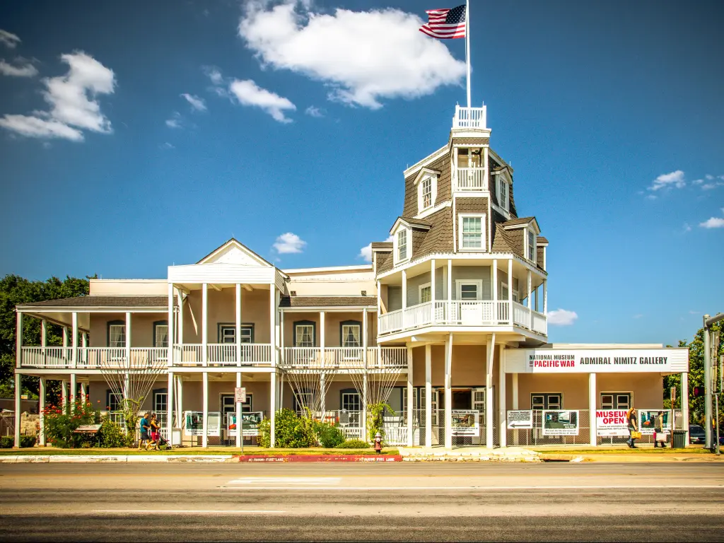 Historic white wood built building with balconies, verandah, turret, flying the stars and stripes
