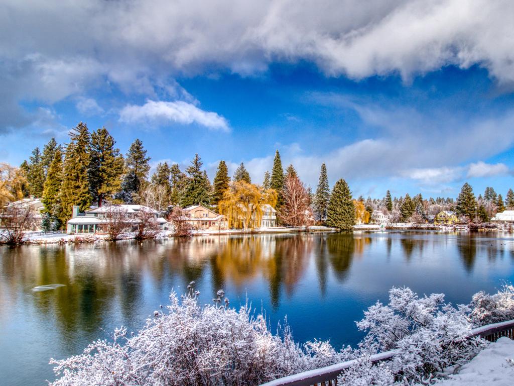 Snow covered ground and winter view of Mirror Pond on Deschutes River from Drake Park