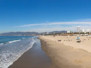 A panorama picture of the Santa Monica State Beach, with waves lapping against sandy shore
