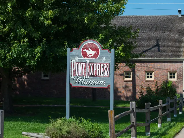 The sign of the historic museum, with the backdrop of a building and trees