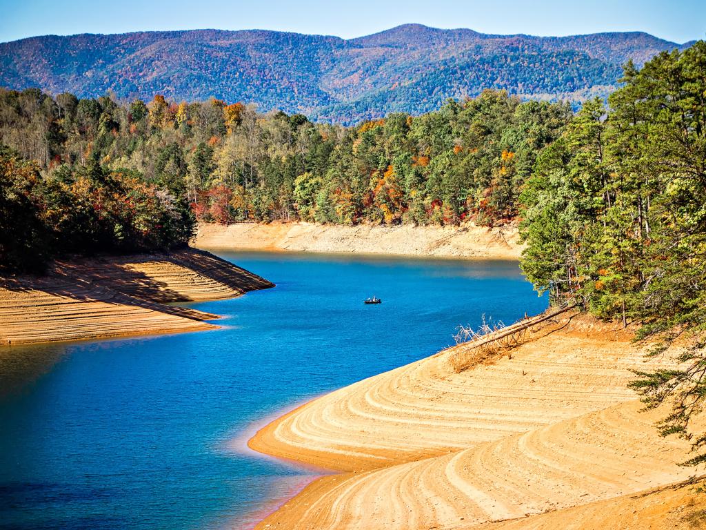 A river with yellow sandy banks runs through the landscape near The Great Smoky Mountains and Fontana Lake