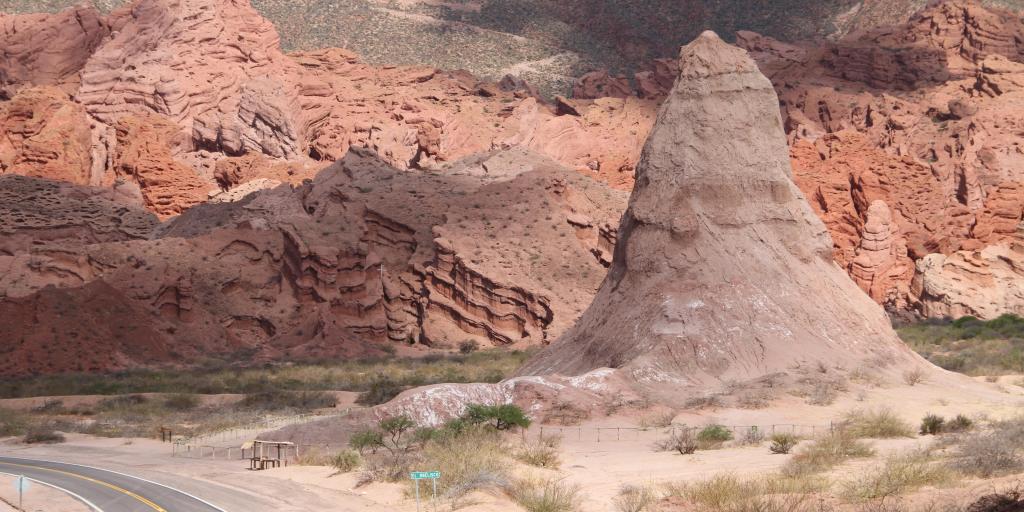 The red mound of rock known as El Obelisco, in Quebrada de las Conchas, Argentina, with a road next to it