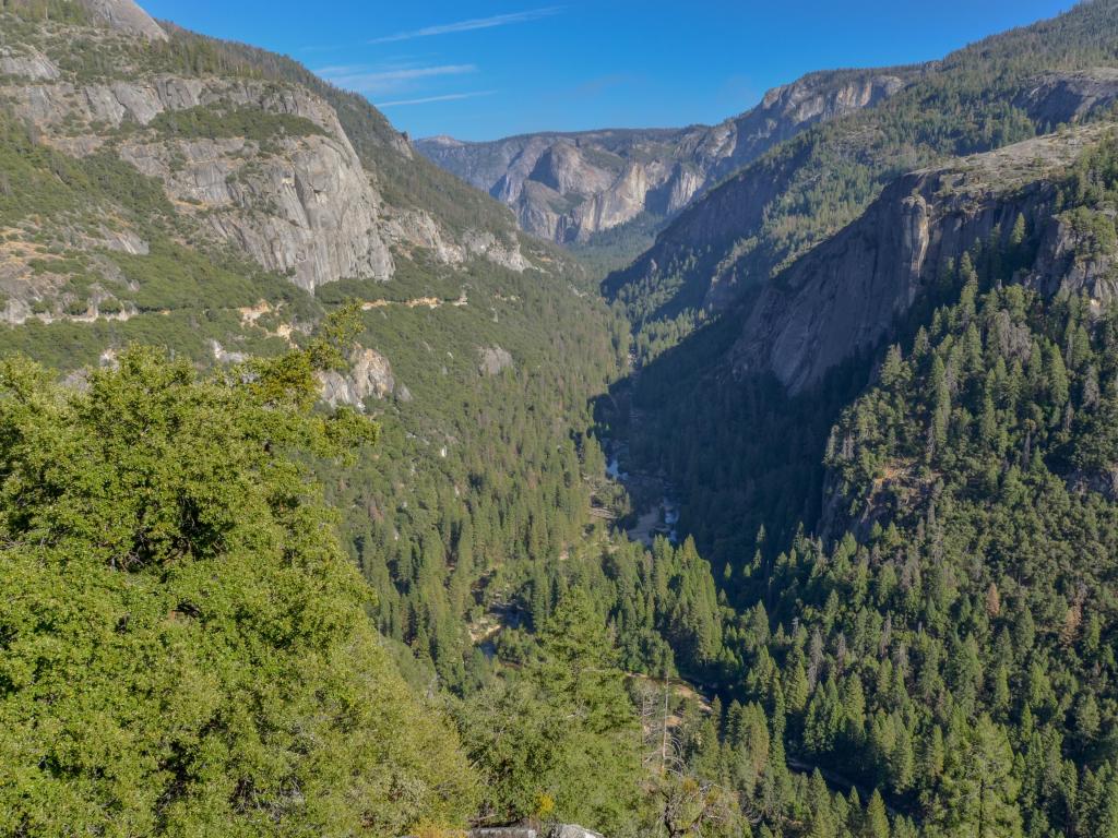 Wide view across Yosemite valley and dense forests and Merced river from Big Oak Flat Road