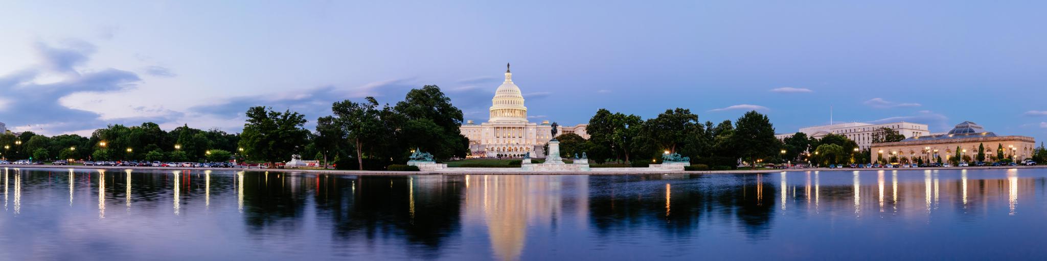 United States Capitol building in Washington DC, with the Capitol Reflecting Pool in the foreground, at dusk