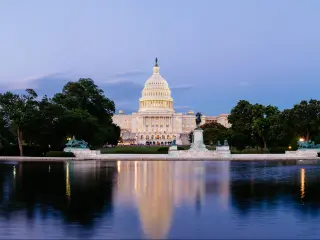 United States Capitol building in Washington DC, with the Capitol Reflecting Pool in the foreground, at dusk