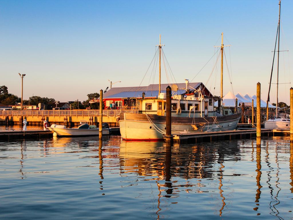 Sunrise in the marina with small boats moored in front of a low rise building