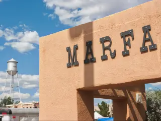 Marfa bus stop with famous Marfa water tower in the background on a sunny day.