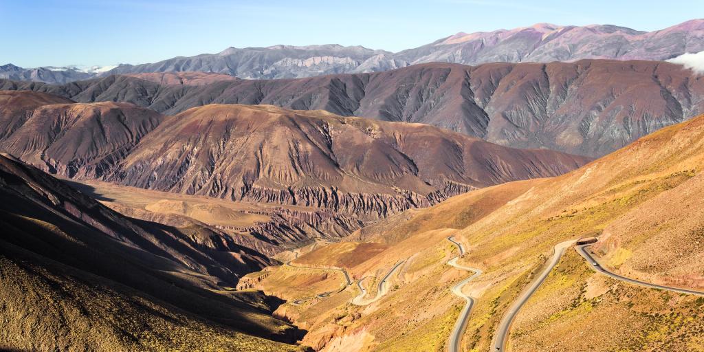 A view of the switchbacks of Cuesta de Lipan, Argentina, on a sunny day, with mountains in the background