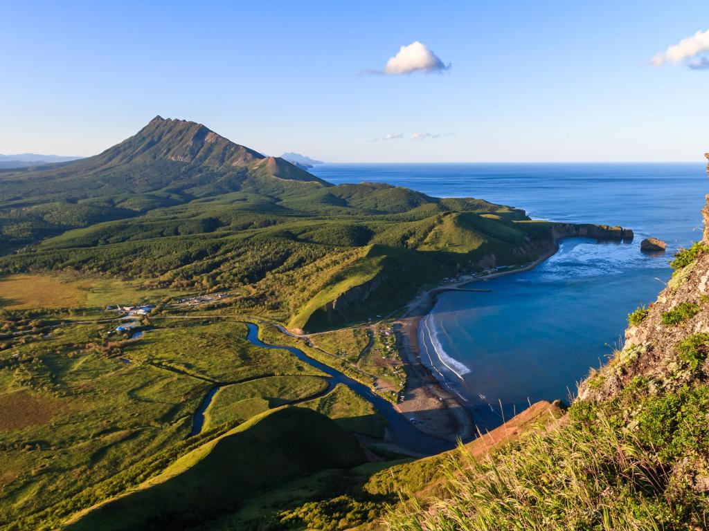 Aerial view of clear waters at Tikhaya Bay and Sea of Okhotsk, surrounded by lush forests on a sunny day, Sakhalin Island, Russia