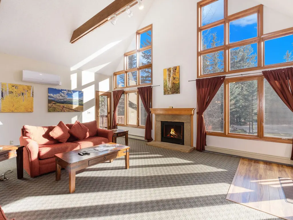 The interior of a hotel suite with a real fireplace and big windows overlooking the scenery