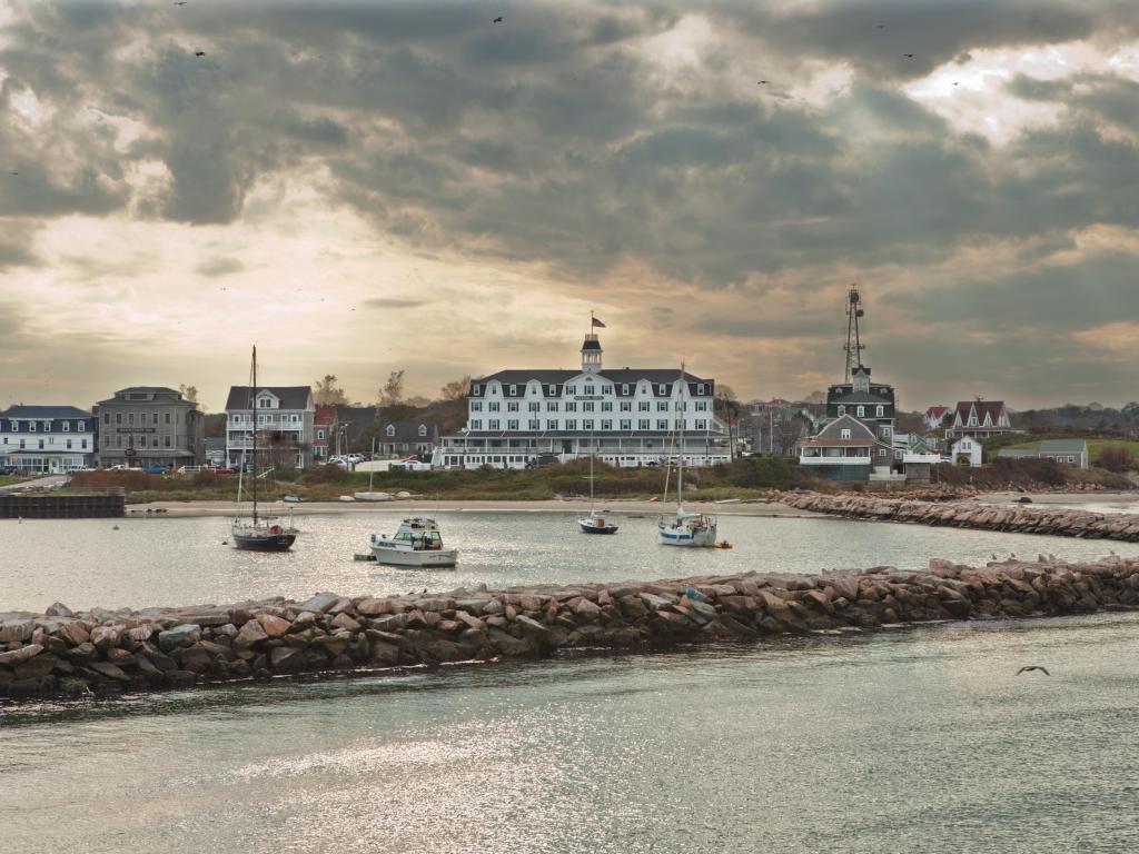 Small boats docked at the harbor with buildings in the background on an overcast day