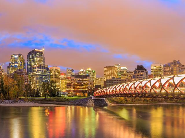Skyline of Calgary and famous red bridge during sunset