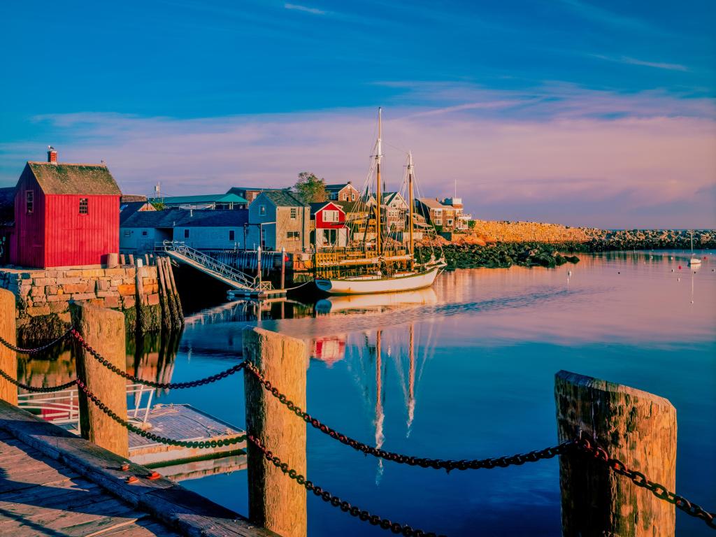 Wooden posts of the wharf in the water at Rockport Harbor in Massachusetts at sunset