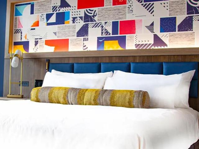 Bright primary coloured artwork on bedroom wall, bold cushions in bedroom at The Landing Hotel at Rivers Casino Pittsburgh