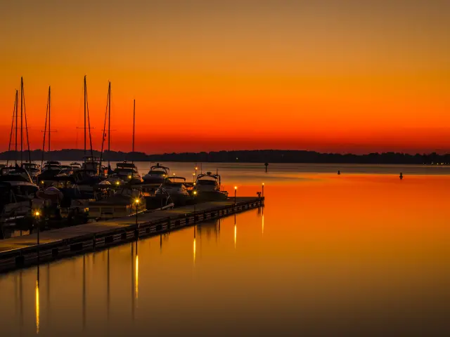 Stunning orange sunset over the lake near Cornelius, with boats docked in the distance