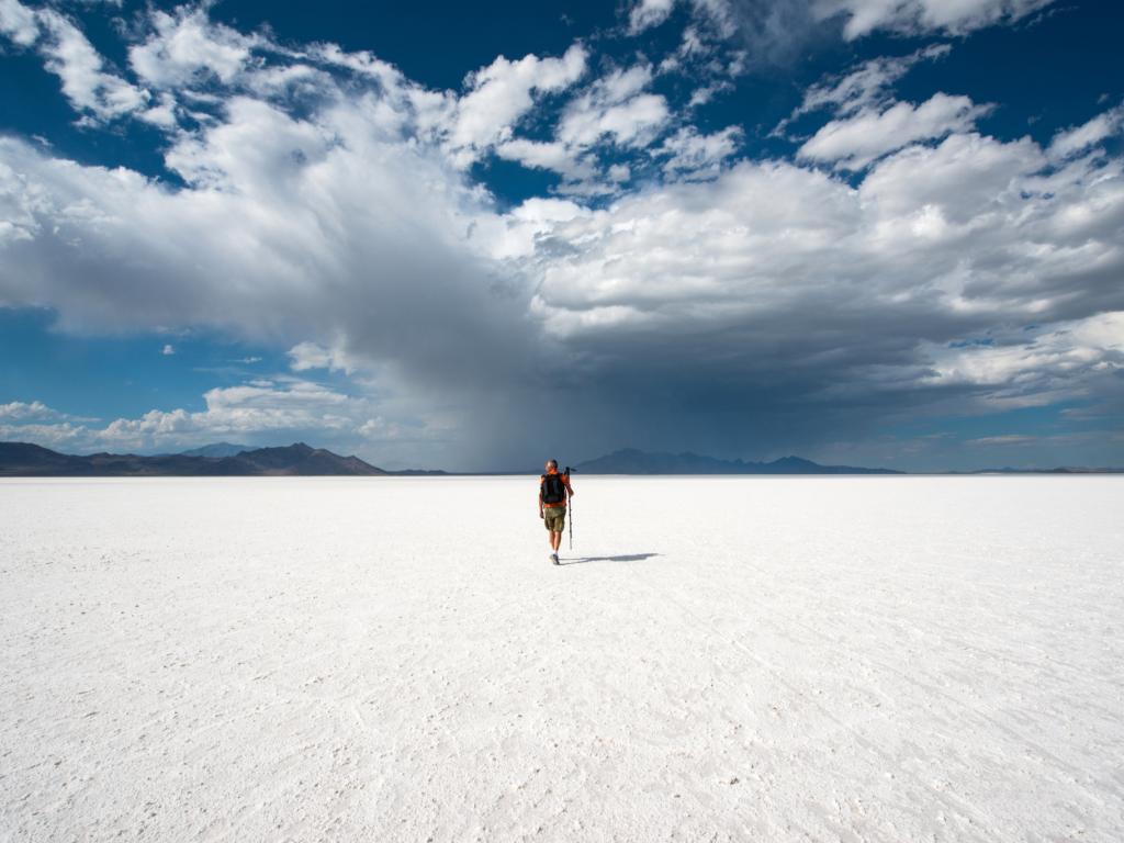 A person walks across the white expanse of the Bonneville Salt Flats in Utah, USA