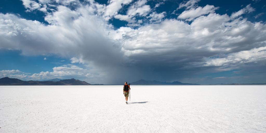 A person walks across the white expanse of the Bonneville Salt Flats in Utah, USA