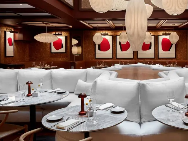 Modern and bright dining room, with large white sofas and red artwork at Lyle DC Hotel in Washington DC